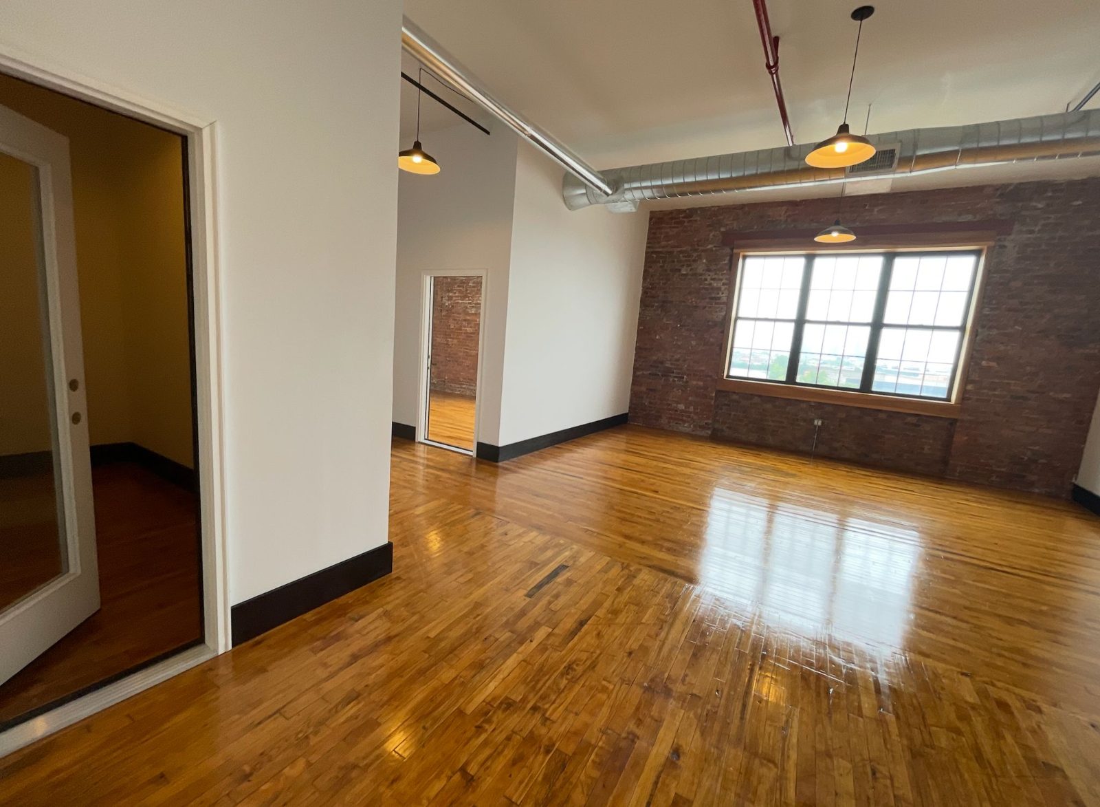 Unit 400 looking toward the entry, with exposed ductwork and pendant lighting